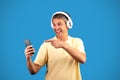 Excited mature man wearing headphones using musical application in studio Royalty Free Stock Photo