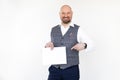 Excited middle-aged man in grey checkered vest, blue jeans, white shirt hold pointing finger at blank sheet of paper. Royalty Free Stock Photo