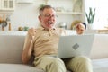 Excited middle aged senior man euphoric winner. Older mature grandfather looking at laptop reading great news getting Royalty Free Stock Photo