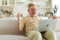 Excited middle aged senior man euphoric winner. Older mature grandfather looking at laptop reading great news getting Royalty Free Stock Photo