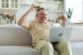 Excited middle aged senior man euphoric winner. Older mature grandfather looking at laptop reading great news getting Royalty Free Stock Photo