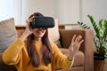 Excited millennial Asian female playing a virtuality game with VR glasses