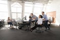 Excited diverse workers have fun racing on chairs in office Royalty Free Stock Photo