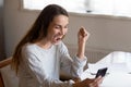 Happy young woman triumph reading good news on cell Royalty Free Stock Photo