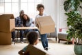 Excited mixed race children holding boxes playing in new home Royalty Free Stock Photo