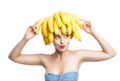 Excited model with bananas on head holding one in hand Royalty Free Stock Photo