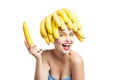 Excited model with bananas on head holding one in hand Royalty Free Stock Photo