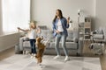 Excited mom and happy daughter kid dancing with pet Royalty Free Stock Photo