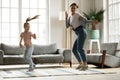 Excited mom teaching daughter girl to dance