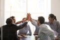 Excited multi racial businesspeople celebrating corporate success giving high five