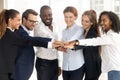 Excited multiethnic employees stack hands showing support and unity Royalty Free Stock Photo