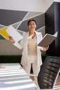 excited multiracial businesswoman in white suit