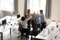 Excited multiracial office workers team giving high five togethe