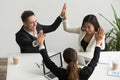 Excited multiracial team holding hands giving high five celebrat Royalty Free Stock Photo