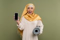 Excited multiracial woman in hijab holding
