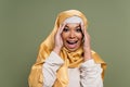 Excited multiracial woman in yellow hijab