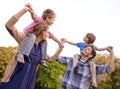 Excited, nature and children on parents shoulders in outdoor park or field for playing together. Happy, bonding and Royalty Free Stock Photo