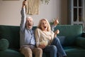 Excited old couple holding remote control watching tv celebrate victory Royalty Free Stock Photo