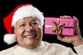 Excited Old Man With Santa Cap And Magenta Gift