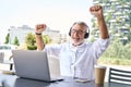 Excited older business man looking at laptop raising fists winning online. Royalty Free Stock Photo