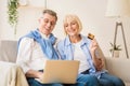 Excited older couple doing online shopping on laptop Royalty Free Stock Photo