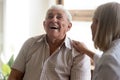 Excited older man patient laughing, having fun with caregiver