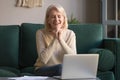 Excited older woman feeling winner sit in front of laptop