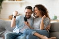 Excited couple holding smartphone celebrating online lottery win