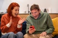 Excited overjoyed millennial happy young family couple looking at phone screen screaming with joy Royalty Free Stock Photo