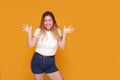 Excited, overjoyed young woman keep mouth open with big smile, closed eyes. Yellow studio background Royalty Free Stock Photo