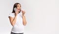 Excited Pregnant Woman Chatting On Cellphone Eating Doughnut, White Background