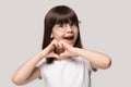 Excited preschool small adorable girl in eyeglasses, showing love sign.