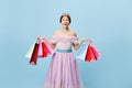 Excited princess. Young woman in image of young queen holding bright shopping packages looking at camera with delight