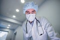 Excited professional doctor in medical mask and looking at camera