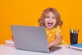 Excited pupil. Excited school child using laptop computer. Back to school. Funny little child from elementary school Royalty Free Stock Photo