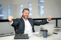 Excited 40s business man working with laptop in office. Gray hair Excited business man director using laptop. Excited Royalty Free Stock Photo