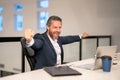 Excited 40s business man working with laptop in office. Gray hair mature business man director using laptop. Millennial Royalty Free Stock Photo