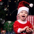 Excited Santa baby laughing while hilding christmas decoration Royalty Free Stock Photo