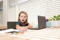 Excited school boy writing at notebook in classroom at the elementary school. Little student doing test in primary Royalty Free Stock Photo