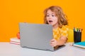 Excited school child using laptop computer. Child from elementary school with book. Little student, clever nerd pupil Royalty Free Stock Photo