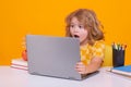 Excited school child using laptop computer. School child student learning in class, study english language at school Royalty Free Stock Photo