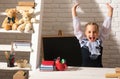 Excited school girl in classroom at school. Amazed kids education and study concept.