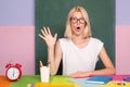 Excited school teacher in class on blackboard background. Professional portrait.