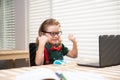 Excited schoolboy using a laptop and study online lesson. Pupil at school. Cute child using laptop computer, studying Royalty Free Stock Photo