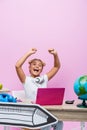 Schoolkid sitting near laptop, globe and