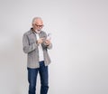 Excited senior businessman reading good news over smart phone and laughing on white background Royalty Free Stock Photo