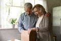 Excited senior couple unboxing postal delivery receive great gift surprise