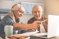 Excited senior husband and wife using laptop in kitchen Royalty Free Stock Photo