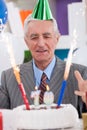 Excited senior man looking at his birthday cake