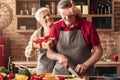 Excited senior woman giving gift to her loving husband at kitchen Royalty Free Stock Photo